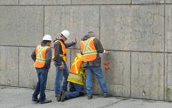 Engineers assessing a Rhode Island concrete wall affected by map-pattern cracking, a symptom typical of alkali-silica reactivity (ASR).